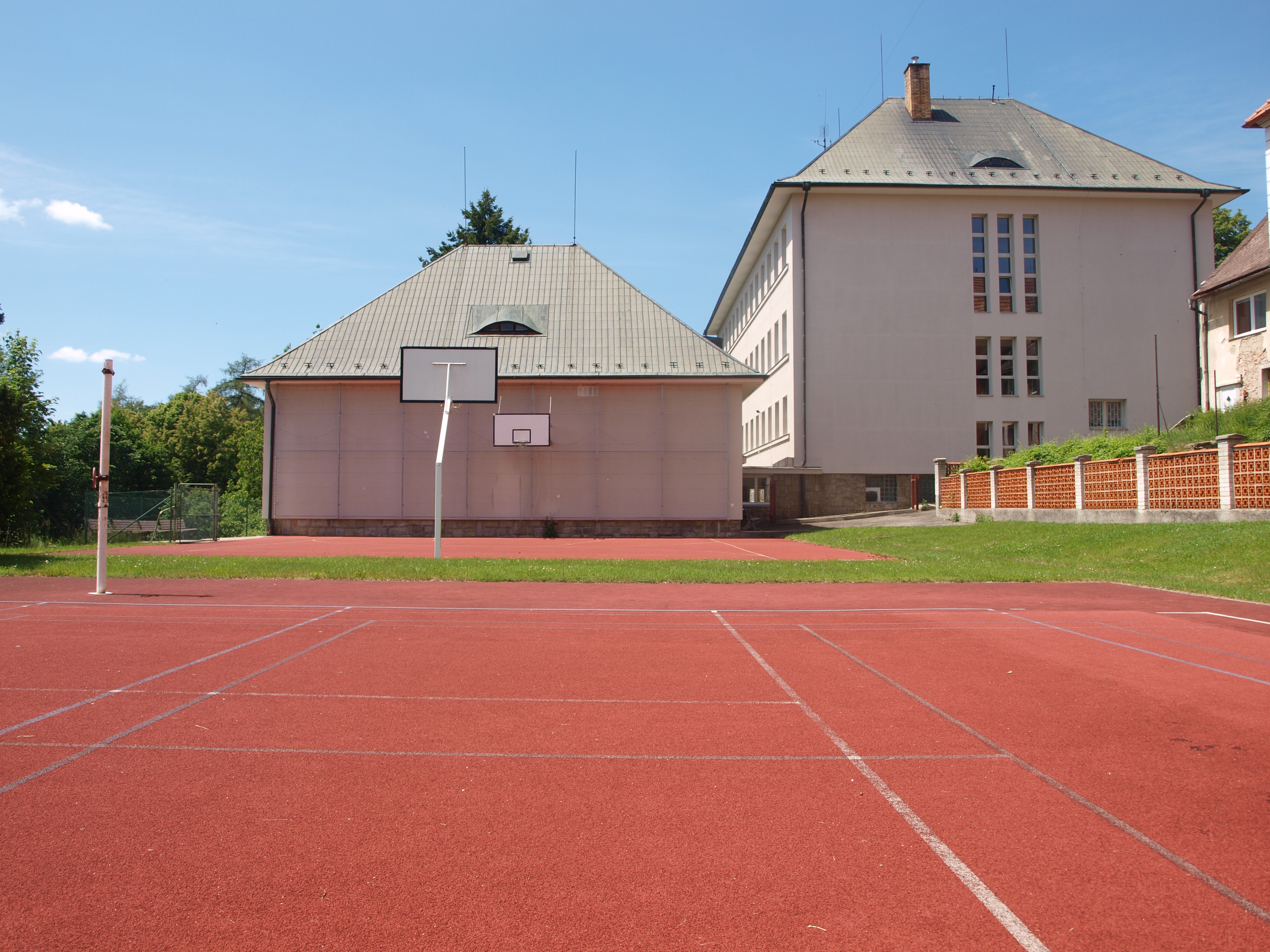 Školní hřiště, pohled na tělocvičnu a budovu II. st.